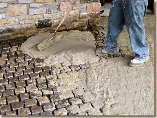 spreading wet grout over setts